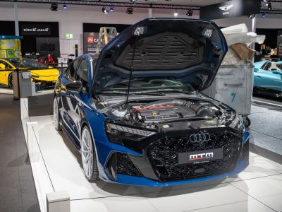 Blue sports sedan with open hood displaying a tuned engine