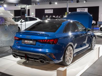 Rear view of a blue sedan with quad exhaust pipes and sporty design