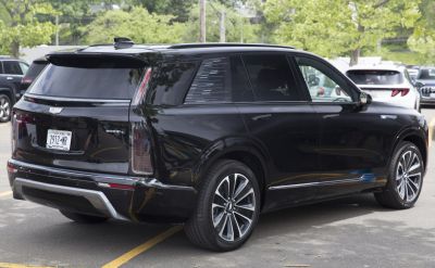 Rear view of a black electric SUV with vertical LED tail lights and alloy wheels.