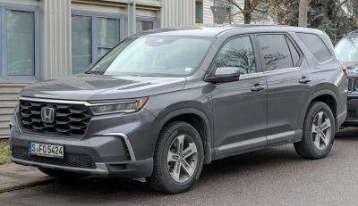 Front side view showcasing bold grille and sleek headlights.