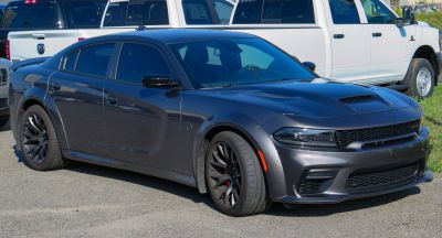 Widebody muscle sedan with sculpted hood and black alloy wheels