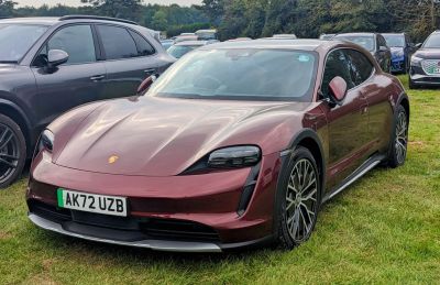 Red electric crossover with aggressive LED headlights and aerodynamic body.