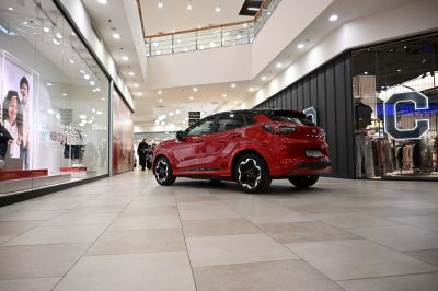 Red compact SUV rear side in modern indoor setting