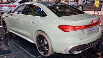 Rear and side view of a modern sedan with sleek tail lights and black alloy wheels
