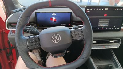 GTI steering wheel with dual digital displays in modern car interior.