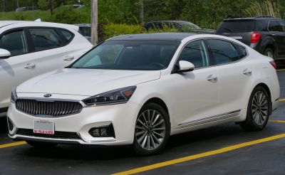 White luxury sedan with prominent front grille and alloy wheels