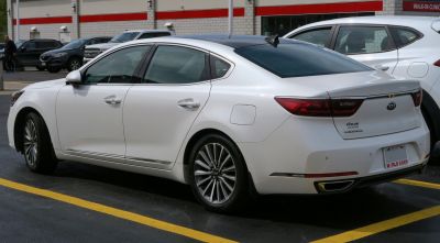 Rear side view of a white modern sedan with distinctive taillights and sleek design
