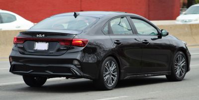 Rear view of a sleek black sedan with modern tail lights and sporty styling.