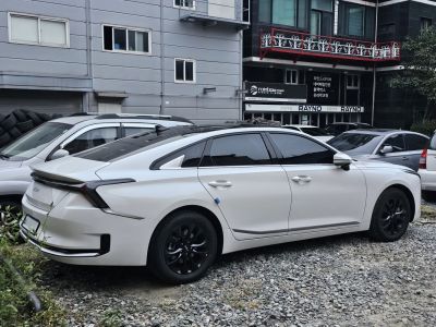 Luxury sedan rear side with black alloy wheels and tinted windows