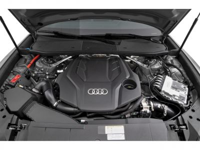 Engine bay with Audi emblem on engine cover and modern components