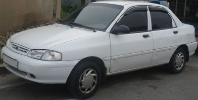 Compact white sedan with distinctive headlights and four doors.
