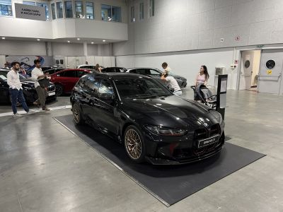 Black high-performance station wagon with sporty front grille and bronze alloy wheels.
