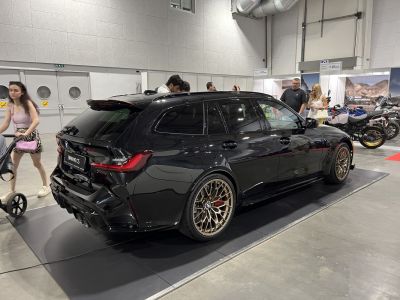 Rear-side view of black sporty estate with bronze wheels and diffuser