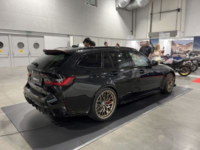 Black sport wagon with bronze multi-spoke alloy wheels in indoor showroom