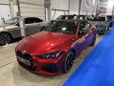 Red convertible with sporty front, black grille, and alloy wheels.