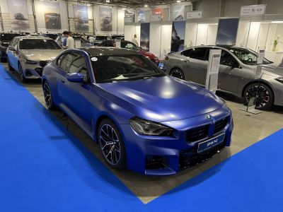 Matte blue coupe with prominent kidney grille and sporty wheels