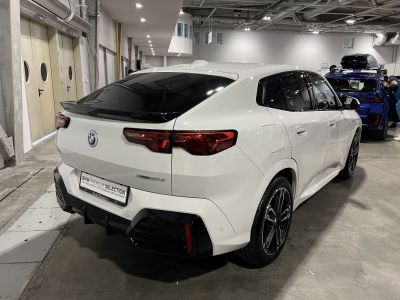 Rear and side view of a white modern SUV with sleek black wheels and aerodynamic design.