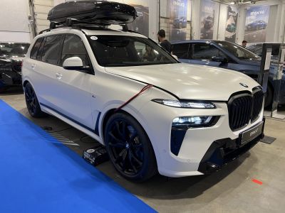White SUV with roof box and black multi-spoke wheels