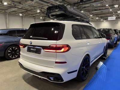 Rear LED taillights and large roof box on white SUV