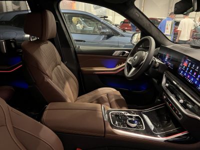 Luxury brown leather seats with advanced digital dashboard and ambient lighting.