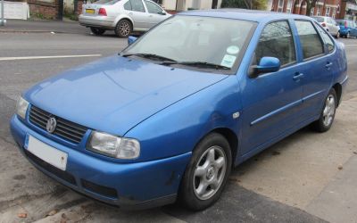 Front side view of a compact hatchback with distinctive headlights and blue paint.