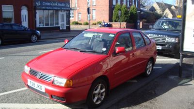 Red compact hatchback with front side view and classic 90s design