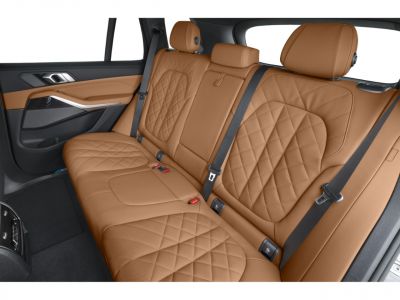 Brown quilted leather rear seats with seat belts and detailed stitching