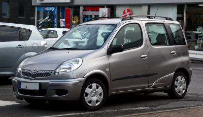 Front-side view of compact MPV with rounded headlights and roof rails