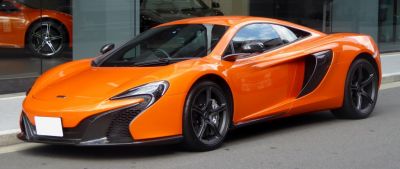 Bright orange sports coupe with prominent aerodynamic features and sleek headlight design
