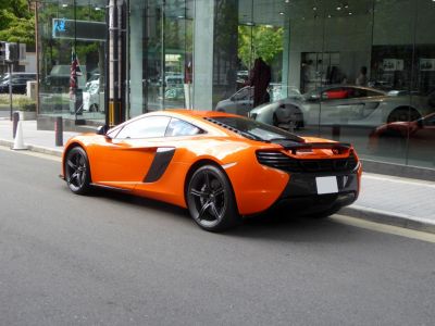 Rear side view of orange 2014 650S coupe with black wheels