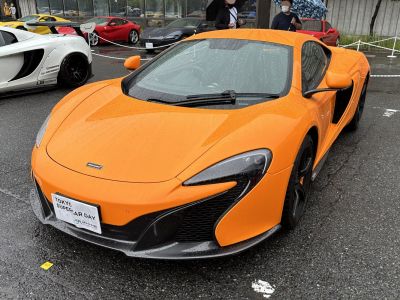 Orange sports car front profile with aerodynamic LED headlights and aggressive front bumper.