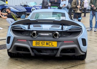 Twin central exhausts and raised rear spoiler on sports car back