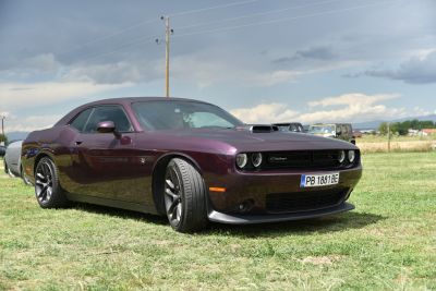 Muscle car front-side view with hood scoop and sporty wheels