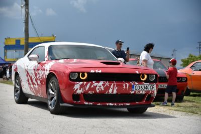 Red and white custom painted muscle car with circular headlights front view