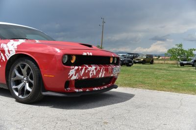 Front design and illuminated headlights of a muscle car with sporty wheels