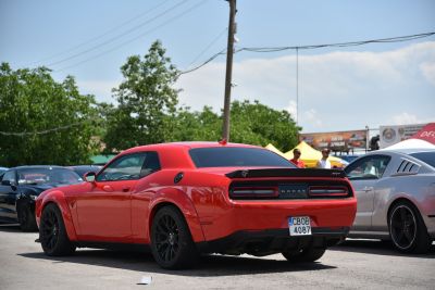 Rear view of a muscle car with wide rear tires and a black spoiler