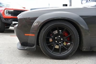 Black alloy wheel with red brake caliper on muscle car