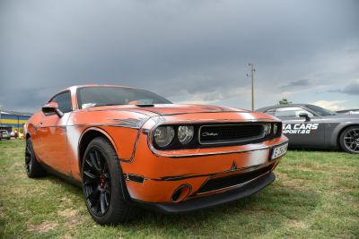 Custom orange muscle car front view with black rims
