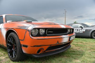 Close-up of front with orange paint, black graphic accents, and black alloy wheels