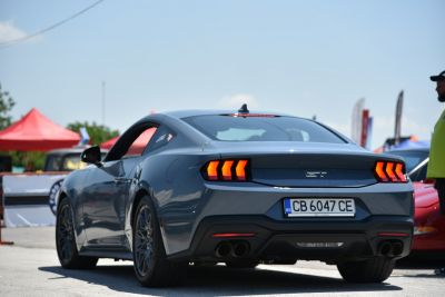 Triple vertical LED taillights and quad exhaust pipes on a sports coupe rear