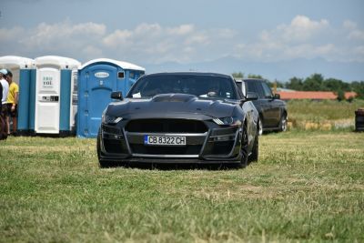 Front view of black muscle car with aggressive hood and wide fenders