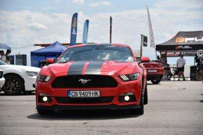 Front view of Mustang with racing stripes and iconic grille emblem