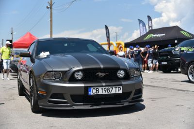 Front grille, headlights, and dual racing stripes on a sporty vehicle.