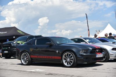Black Mustang coupe with red racing stripes and alloy wheels