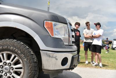 Close-up of truck front grille, headlight, and rugged off-road tire tread