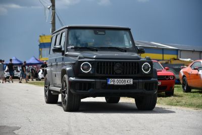 Front view with round LED headlights and bold grille.