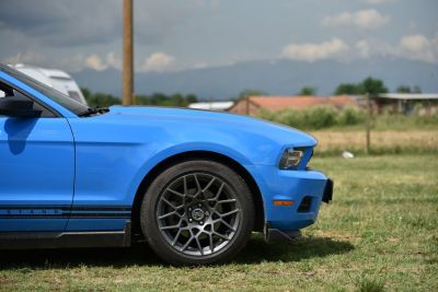 Front side view showing alloy wheel and hood of muscle car