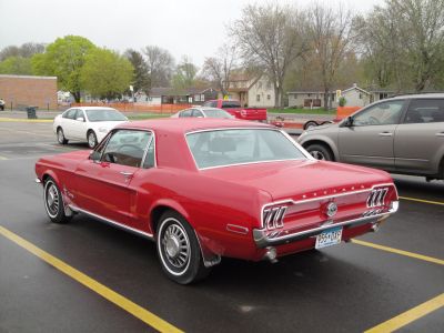 Red classic car rear with triple vertical tail lights and chrome details