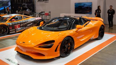 Orange convertible sports car with aerodynamic body and black wheels