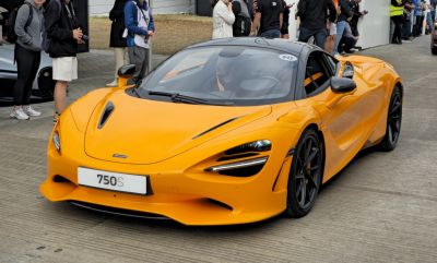 Sleek aerodynamic front design with advanced headlights and vibrant orange paint